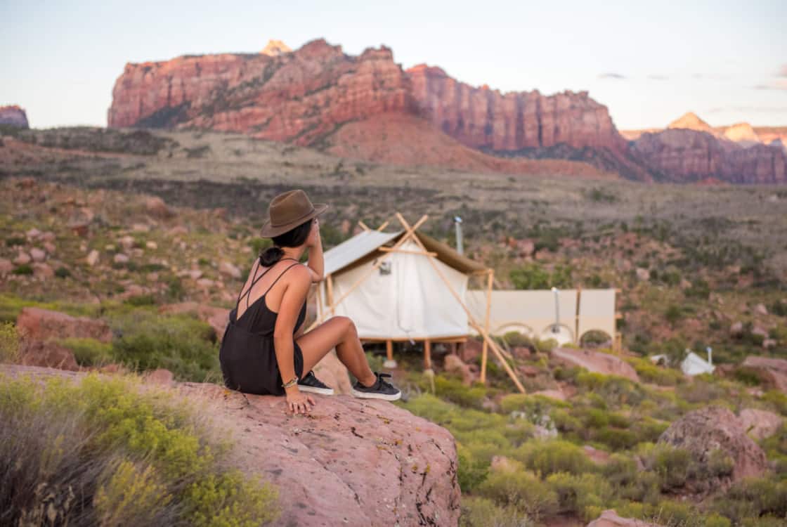 An Under Canvas guest enjoys the Zion views outside her glamping tent.