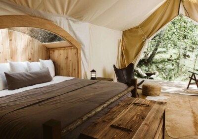 King Bed in Under Canvas Rushmore Glamping Tent with View of Forest