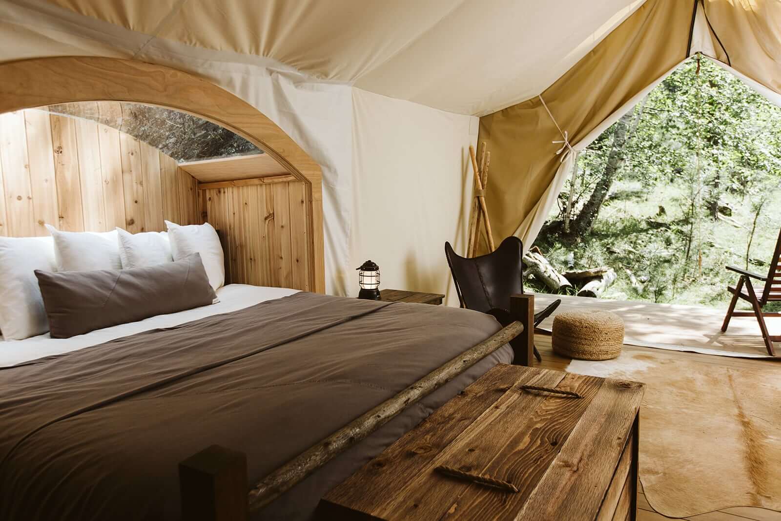 King Bed in Under Canvas Rushmore Glamping Tent with View of Forest