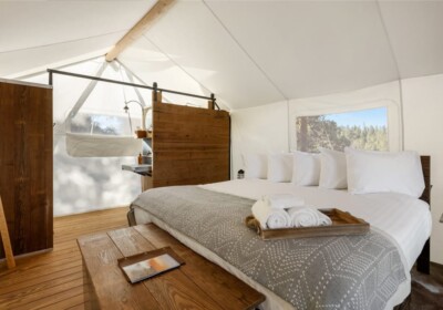 View of Bed and Bathroom in a Deluxe Tent at Under Canvas Bryce Canyon