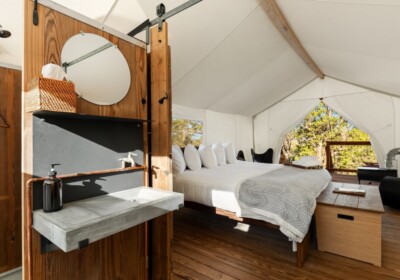 View of Bathroom Sink and Bed in a Deluxe Tent at Under Canvas Bryce Canyon