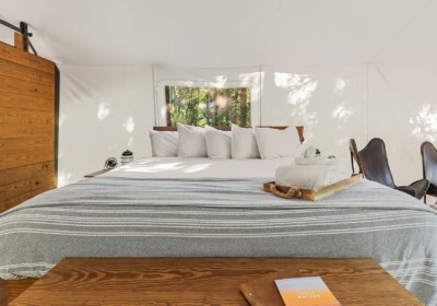 View of Bed in Deluxe Tent at Under Canvas Glacier