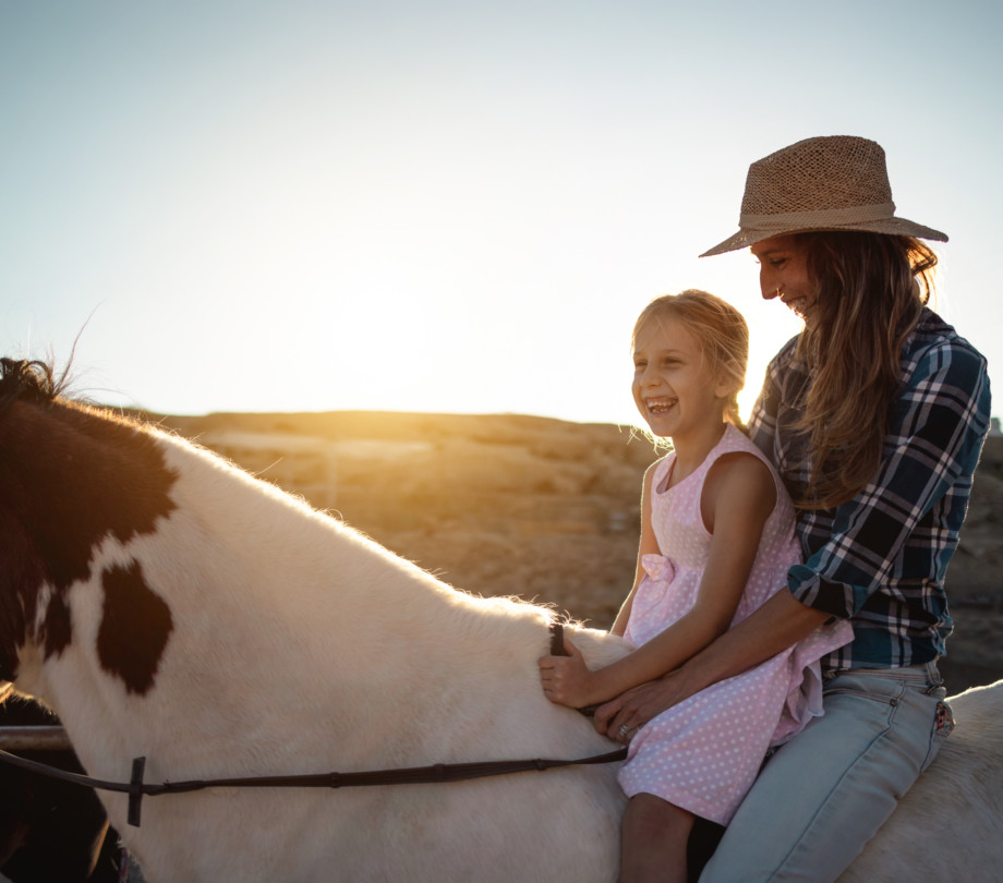 Women riding horse with girl in Utah