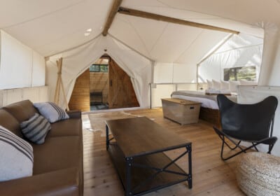 seating area with king bed in a canvas tent