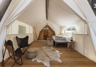 canvas tent with king bed and chairs