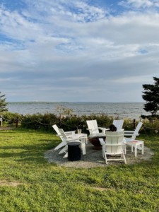 Firepit seating near water at Under Canvas Acadia by Laura Jung