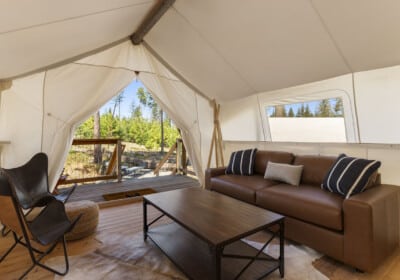couch and sitting area in canvas tent with a view