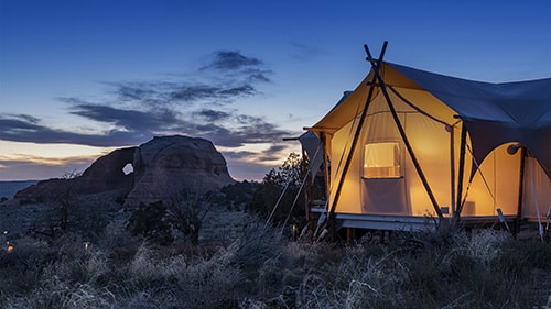 ULUM Moab glowing tent at night with Looking Glass Rock in background