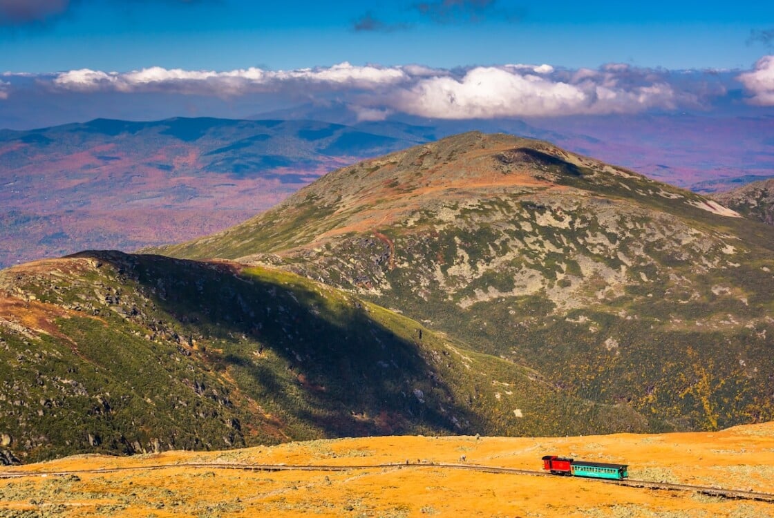 View of The Mount Washington Cog Railway and distant ridges of the White Mountains from the summit of Mount Washington, New Hampshire.
