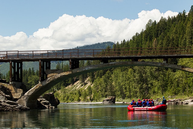 Group of rafters going under a bridge.