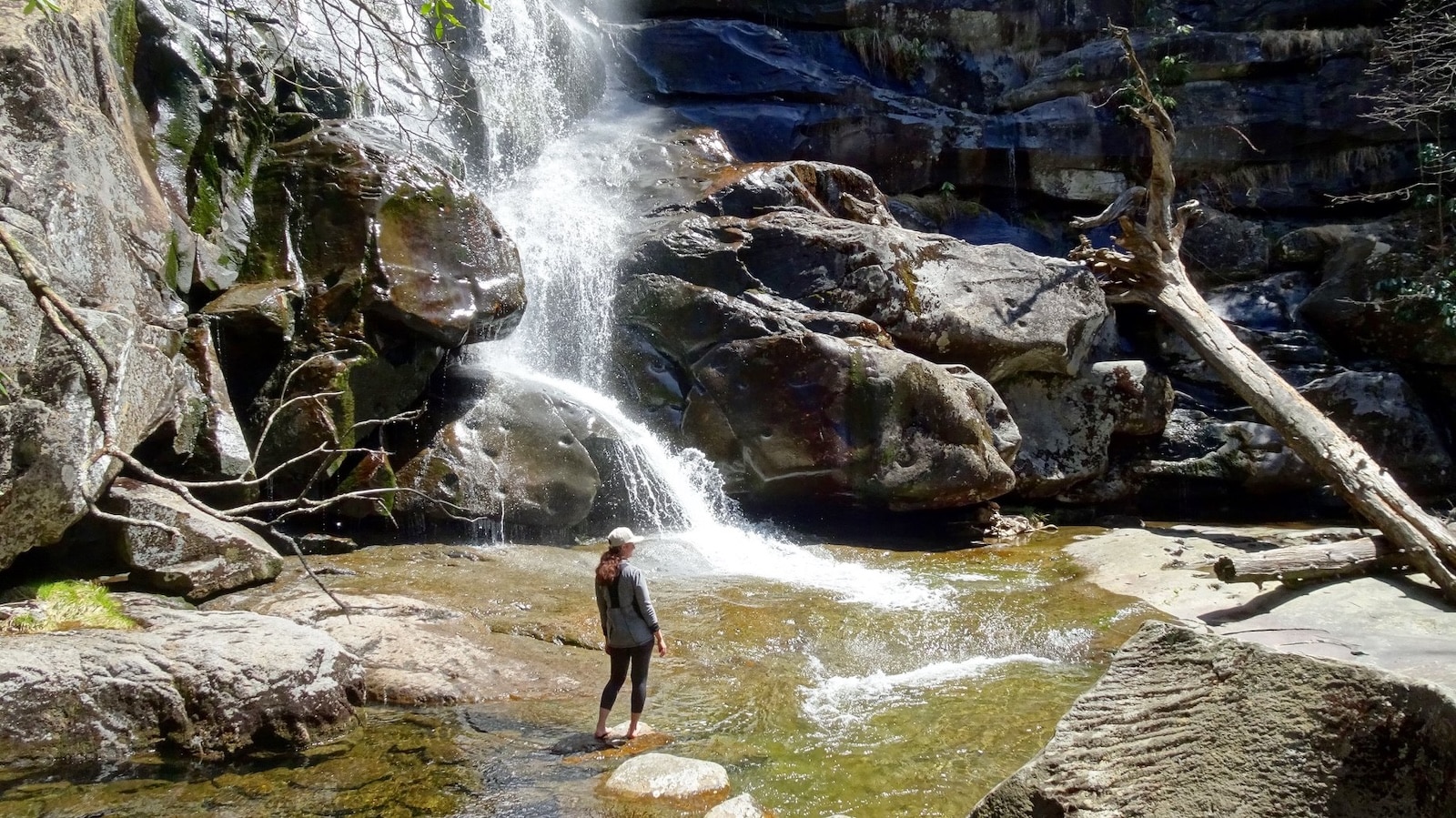 Woman at bottom of waterfall in Great Smoky Mountain National Park.
