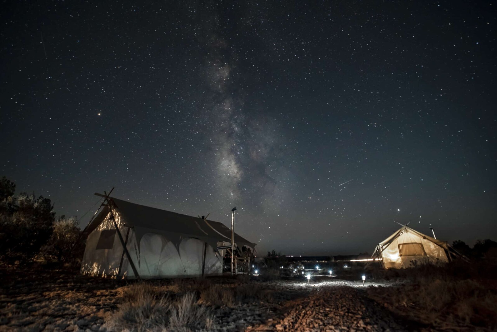 Canvas tents at night with stars in the background