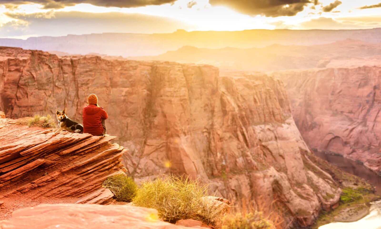 Man sitting on a lookout of the Grand Canyon.