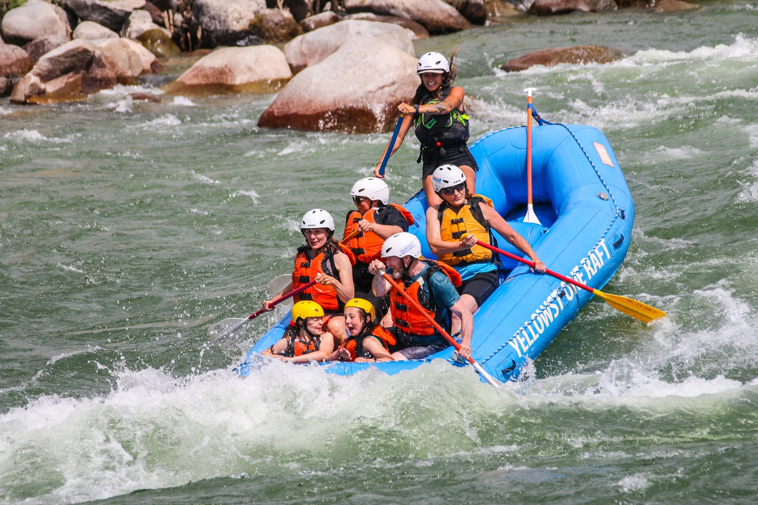 Whitewater rafters going through a rapid.