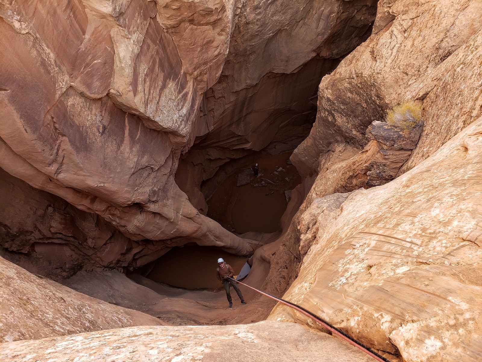 Person rappelling down medieval chamber.