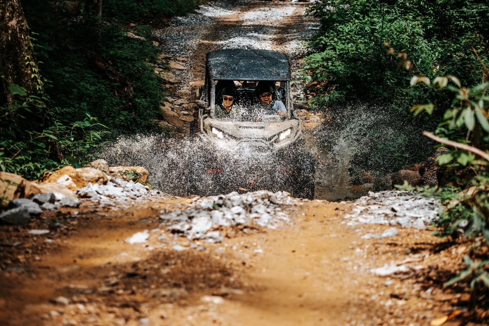 People on a UTV going through a puddle near the Smoky Mountains.
