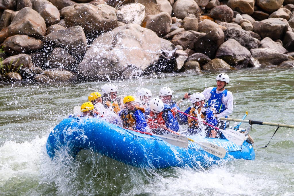 White water rafters going through a rapid.