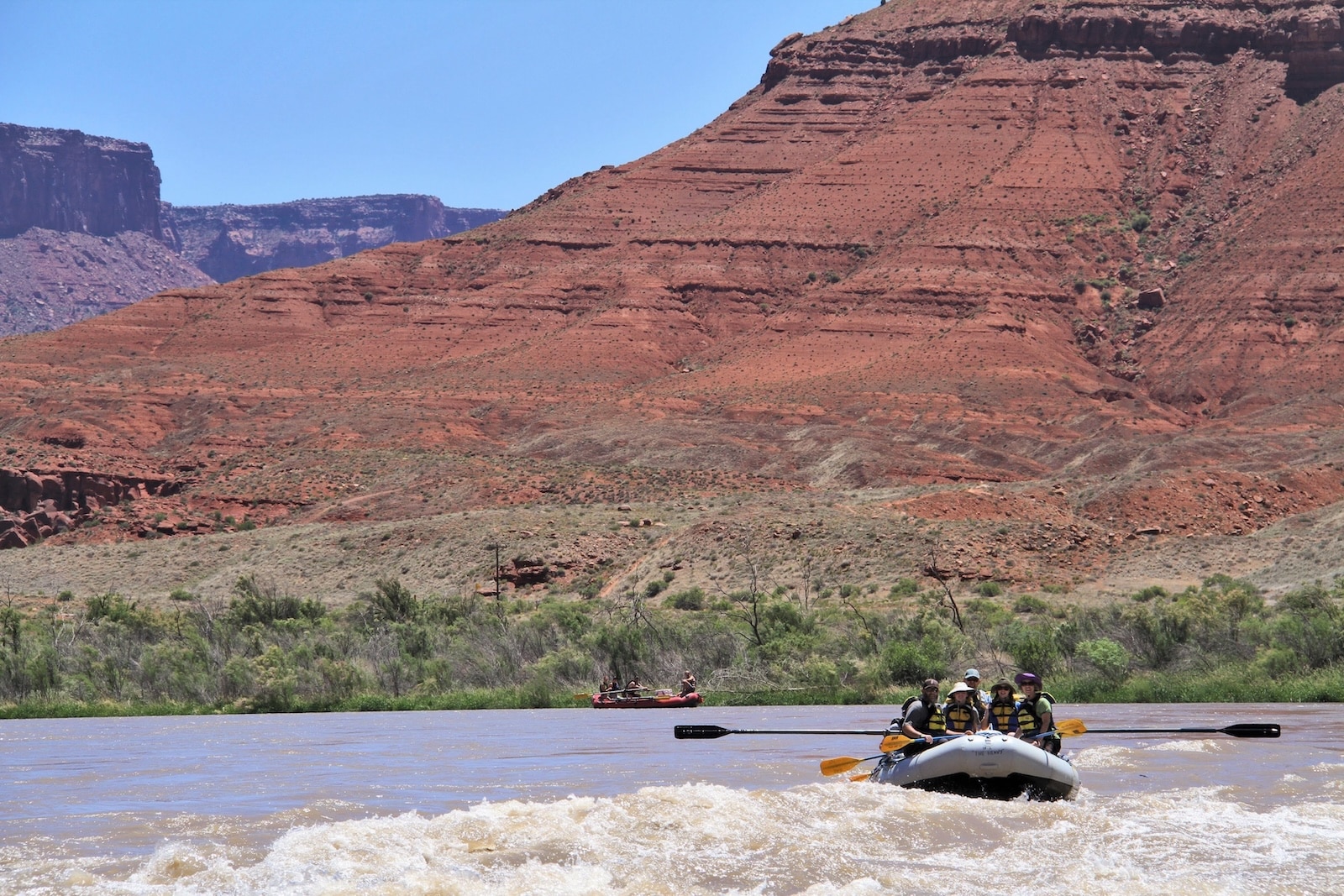 Rafting near Moab with red rock backdrop.