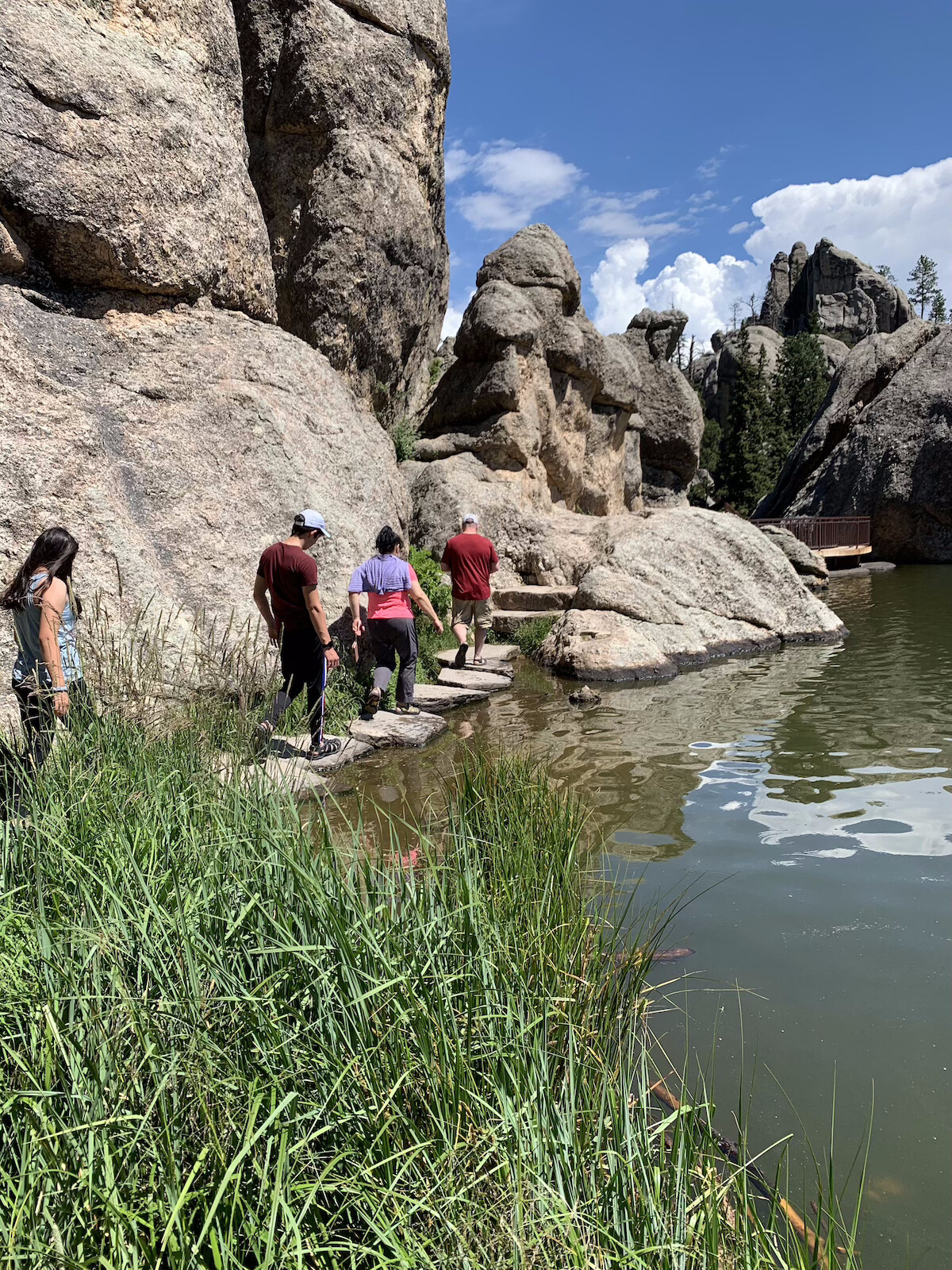 Group of hikers going around a lake in the Black Hills.