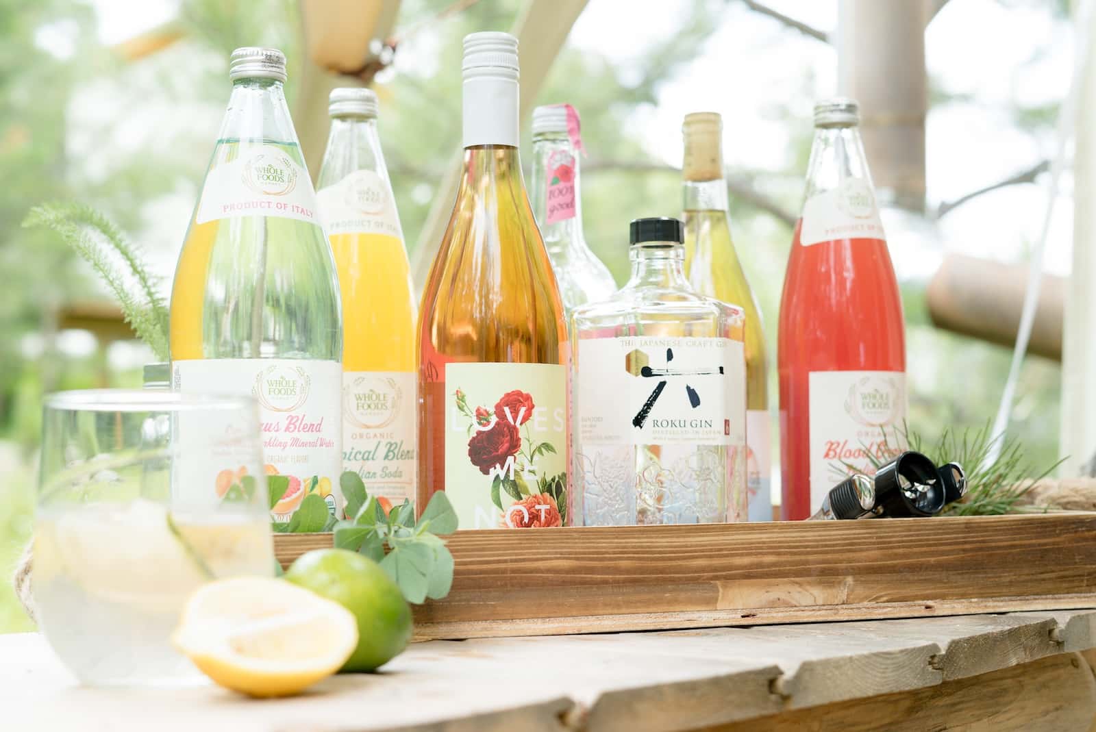 Wines and liquor neatly displayed on a wooden table.