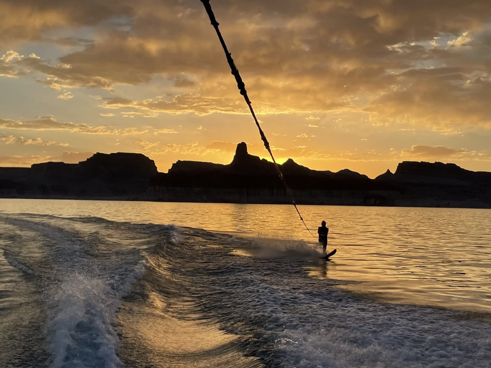 Man wakeboarding on Lake Powell during sunset.