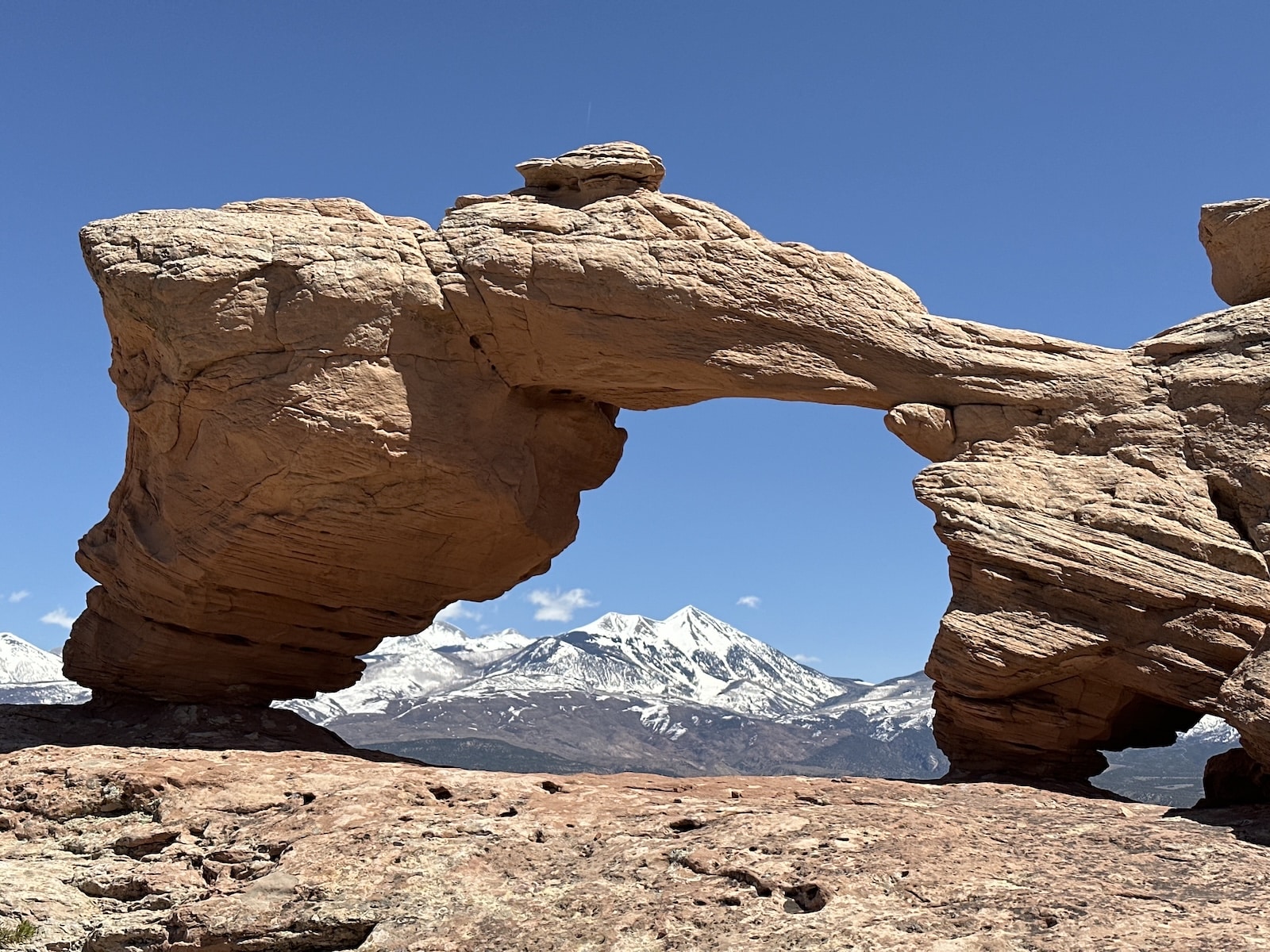 Looking through a rock arch at the la sal mountains.