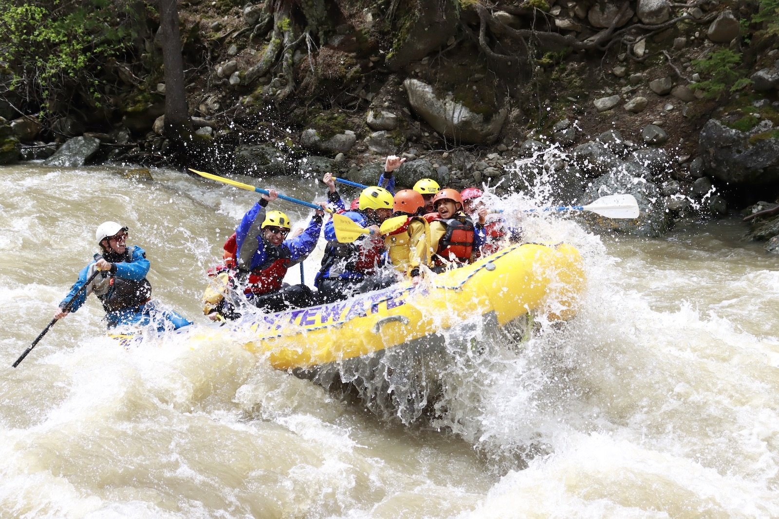 Whitewater rafters going through a big rapid.