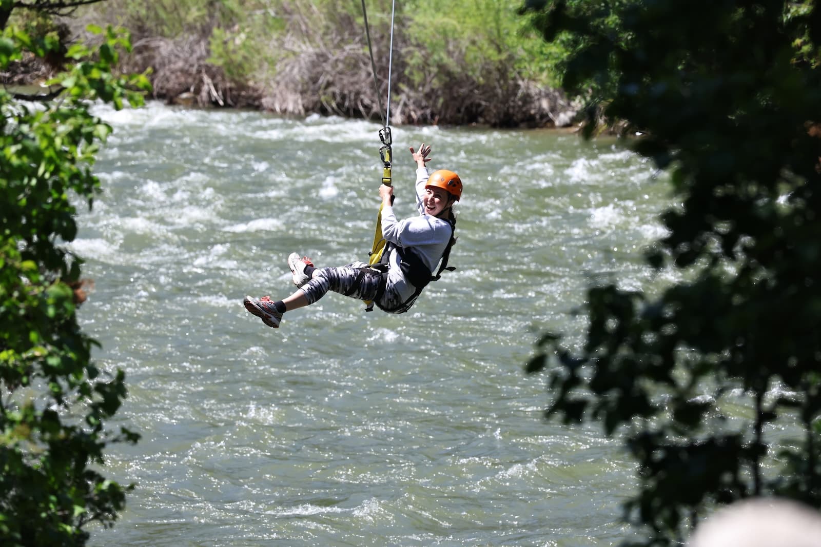 Woman ziplining besides a river in Yellowstone.