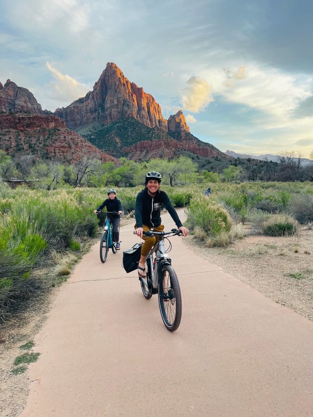 People biking Zion National Park during sunset.