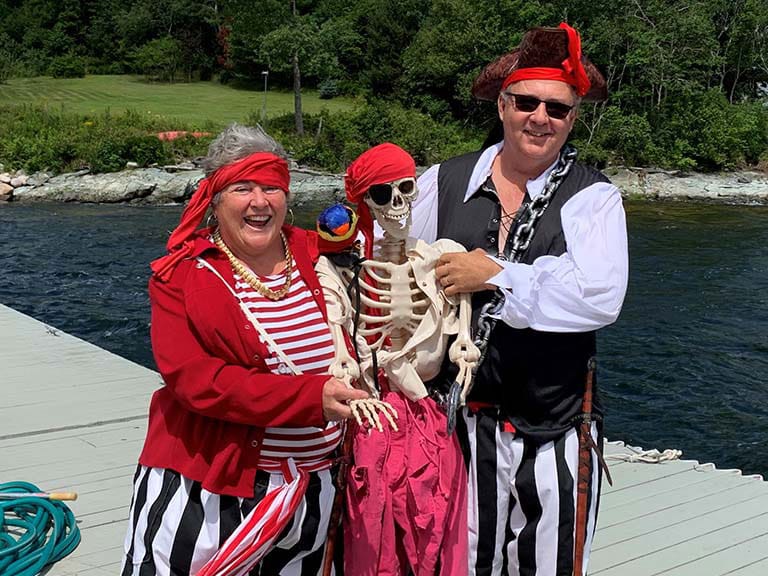 Pirates posing with a fake skeleton for a children's pirate boat ride.