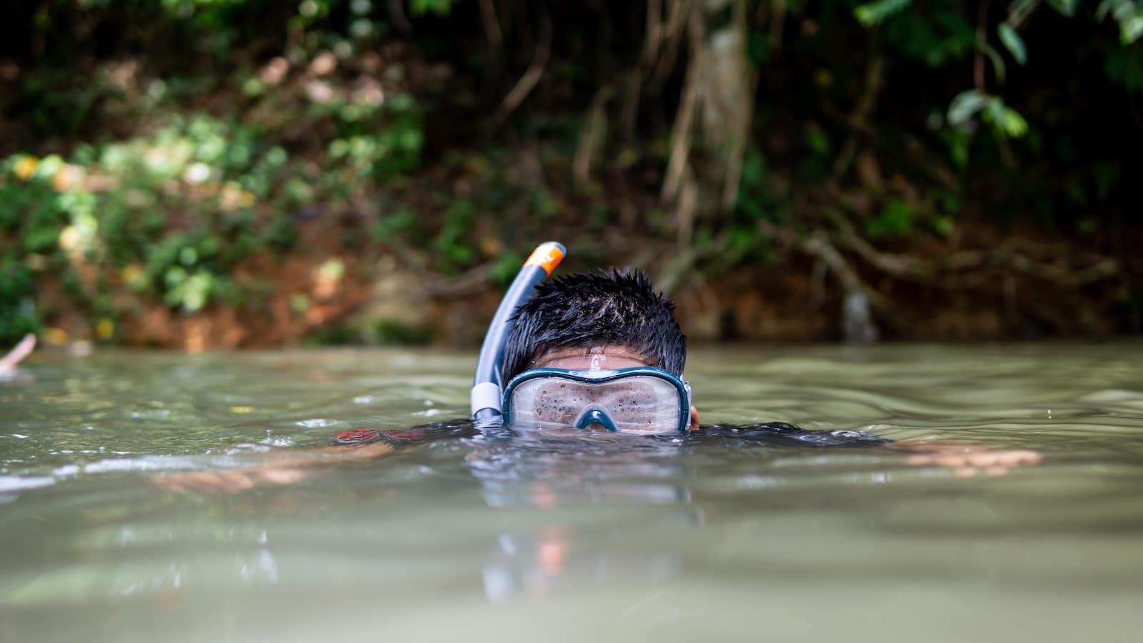 Boy snorkeling in a river.