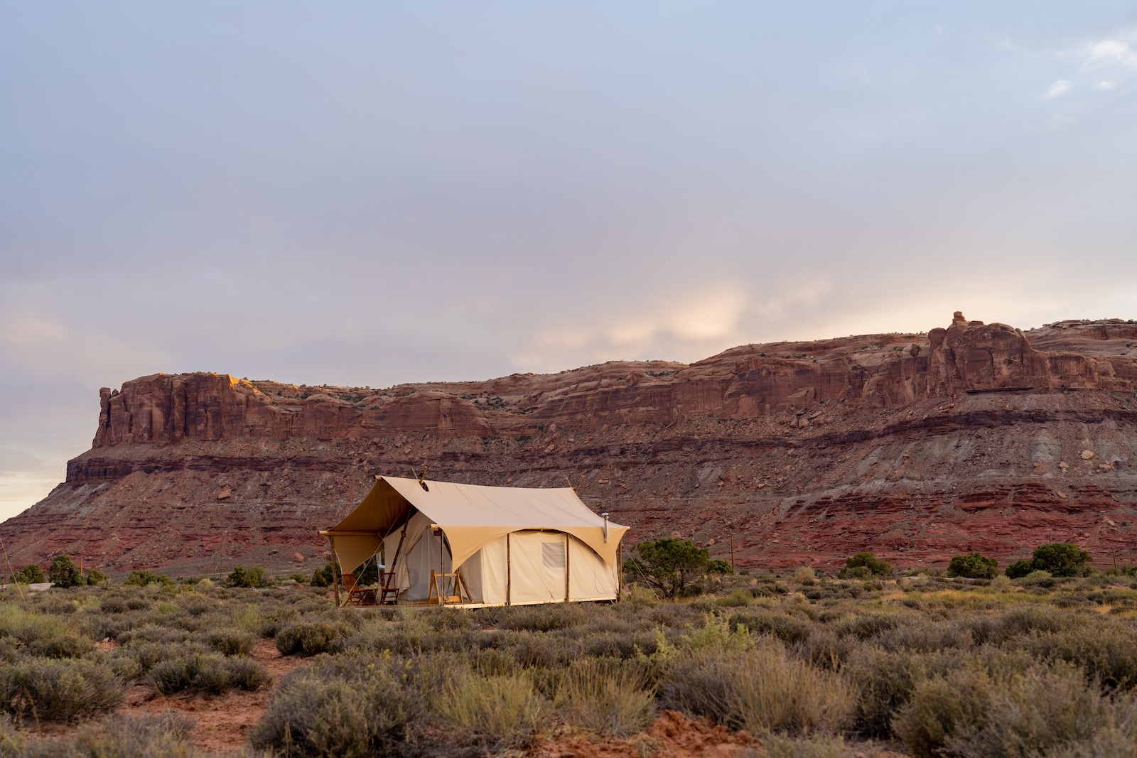 Under Canvas Moab tent with a red rock backdrop.