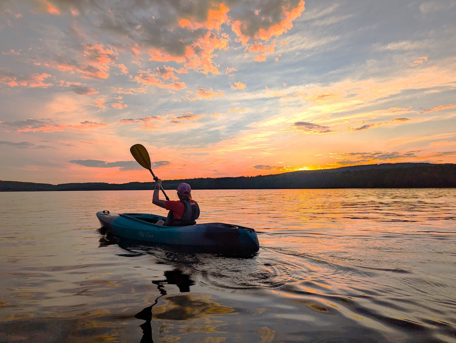 Kayaker on the Moore Reservoir in New Hampshire at sunset.