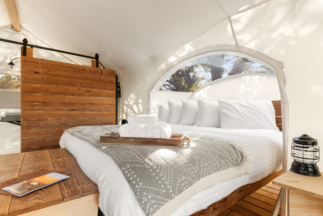 tent interior with chairs wood burning stove kind bed and star viewing window