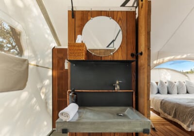 tent interior with chairs wood burning stove kind bed and star viewing window