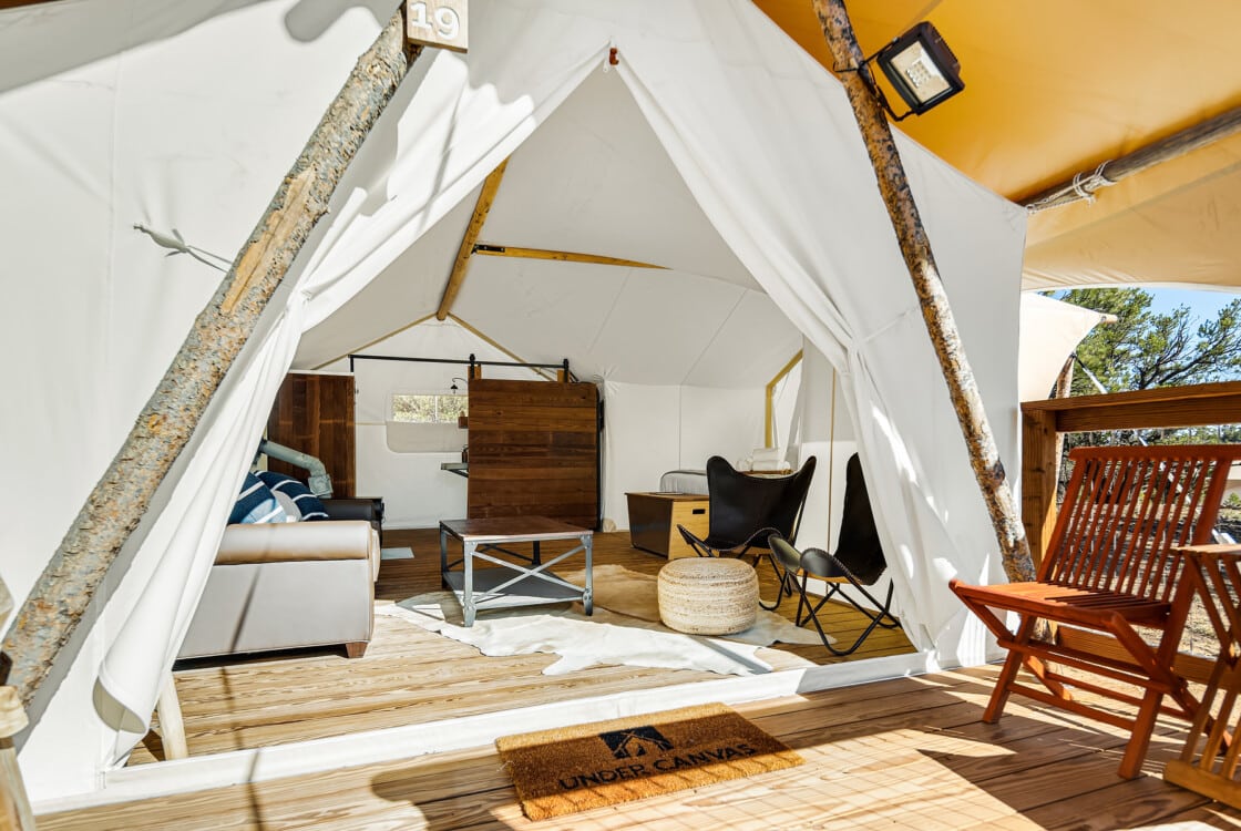 interior tent with couch chairs, king size bed front porch with chairs