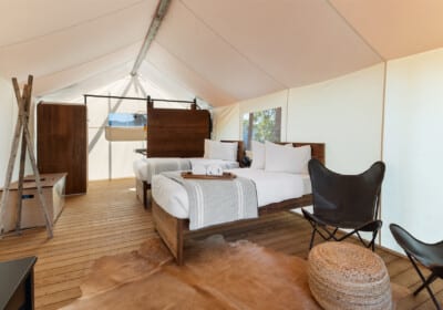 interior tent with couch chairs, king size bed front porch with chairs