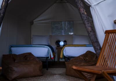 interior kids tent with two twin beds bean bags and chairs on the deck at night
