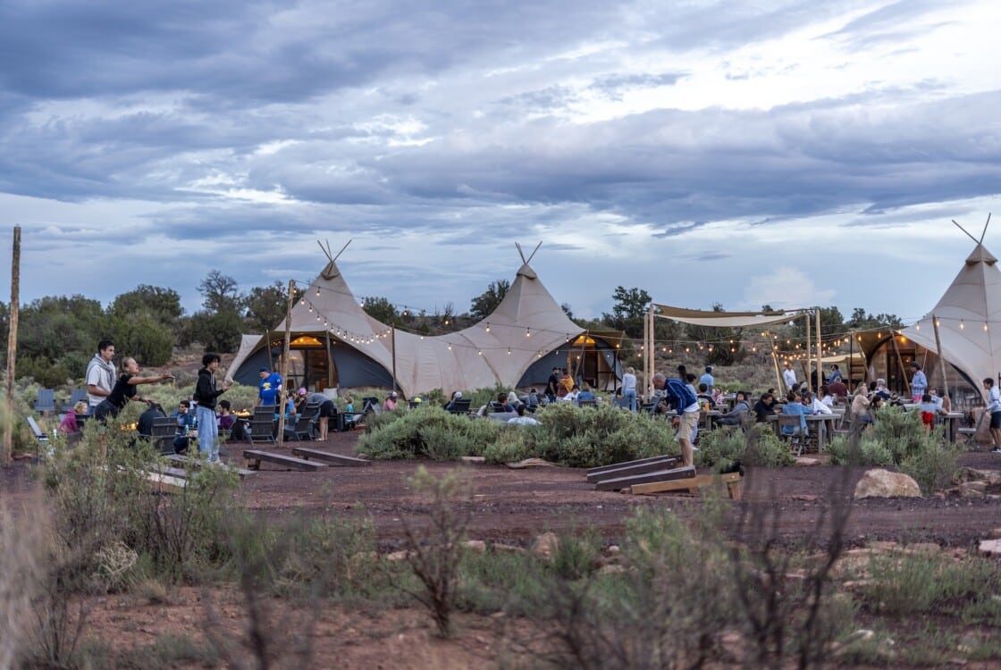 People playing corn hole outside the lobby tent at Under Canvas Santa Fe.